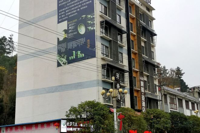 A multi-story building with a large advertisement on the side.