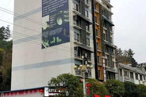 A multi-story building with a large advertisement on the side.