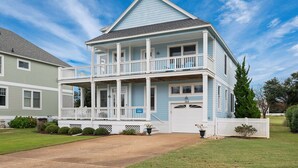 A two-story house with a balcony, a garage, and a well-maintained lawn. - Peace of Paradise: Private Pool, Hot Tub and Great Currituck Club amenities! (Corolla)