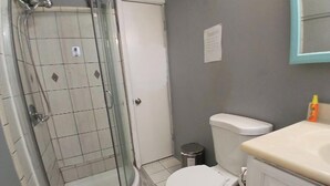 A bathroom with a glass-enclosed shower, a toilet, and a sink. - Private Room with Ensuite Bath - Separate Entrance and Exit! (San Jose)