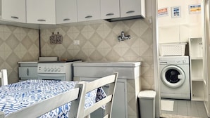 A compact kitchen with a stove, sink, and washing machine. - RM10 - Senigallia, two-room apartment facing the sea (Senigallia)