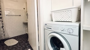 A laundry room with a washing machine, a drying rack, and a white tiled wall. - RM10 - Senigallia, two-room apartment facing the sea (Senigallia)