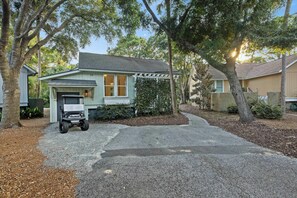 A single-story house with a covered porch, a driveway, and a lawn. - Great FAMILY home in Wild Dunes, Pond View, Modern, Minutes to Beach, Rent the Golf Cart! (Isle Of Palms)