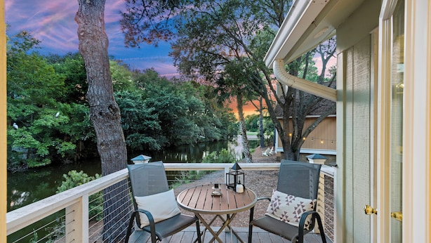 A deck with two chairs and a table, overlooking a body of water and trees. - Great FAMILY home in Wild Dunes, Pond View, Modern, Minutes to Beach, Rent the Golf Cart! (Isle Of Palms)