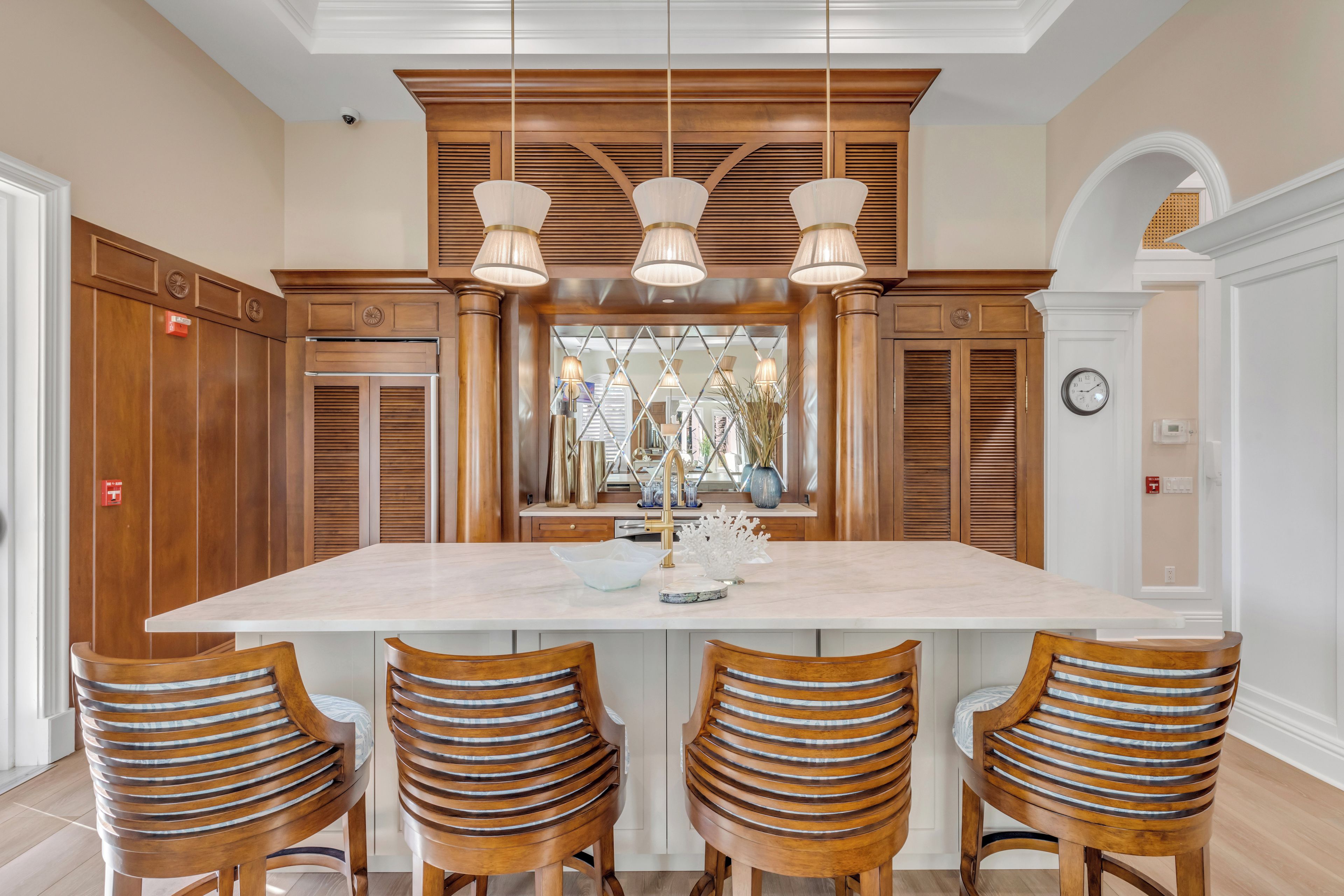 Una cocina amplia con una isla grande, armarios de madera e iluminación colgante moderna.