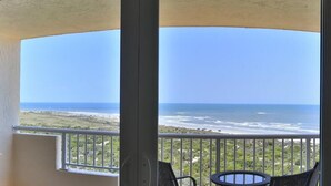 A balcony with a view of the ocean and a table with chairs. - Peaceful Paradise by the Sea | Inlet #1103 (New Smyrna Beach)