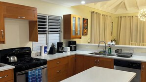 Una cucina moderna con mobili in legno, elettrodomestici in acciaio inossidabile e una grande isola.