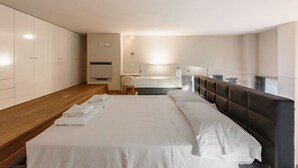 Une chambre d’hôtel moderne, dotée d’un grand lit, d’un bureau et d’une armoire.