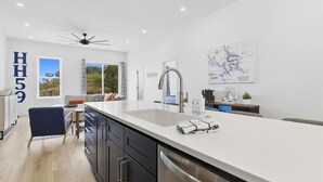 Una cocina moderna con una isla grande, un ventilador de techo y un mapa en la pared.