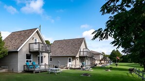 Une rangée de maisons de plain-pied, chacune dotée d’un porche attenant, d’une pelouse bien entretenue et d’espaces aménagés pour se détendre à l’extérieur.