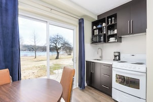 Una cocina moderna con un amplio ventanal, una mesa de comedor y vistas a un lago.