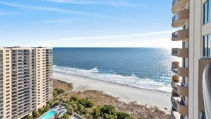 Un hôtel de grande hauteur donnant sur une plage et offrant une vue dégagée sur l’océan.