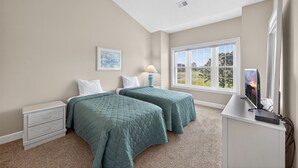 A bedroom with two beds, a desk with a computer, a window with a view, and a nightstand with drawers. - MN 4811-304 | Stay in Golf Paradise Book for Golf Season (Myrtle Beach)