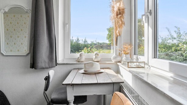 A room with a window, a table, and a chair.