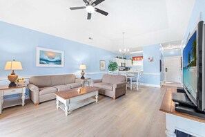 A living room with two sofas, a coffee table, and a TV.