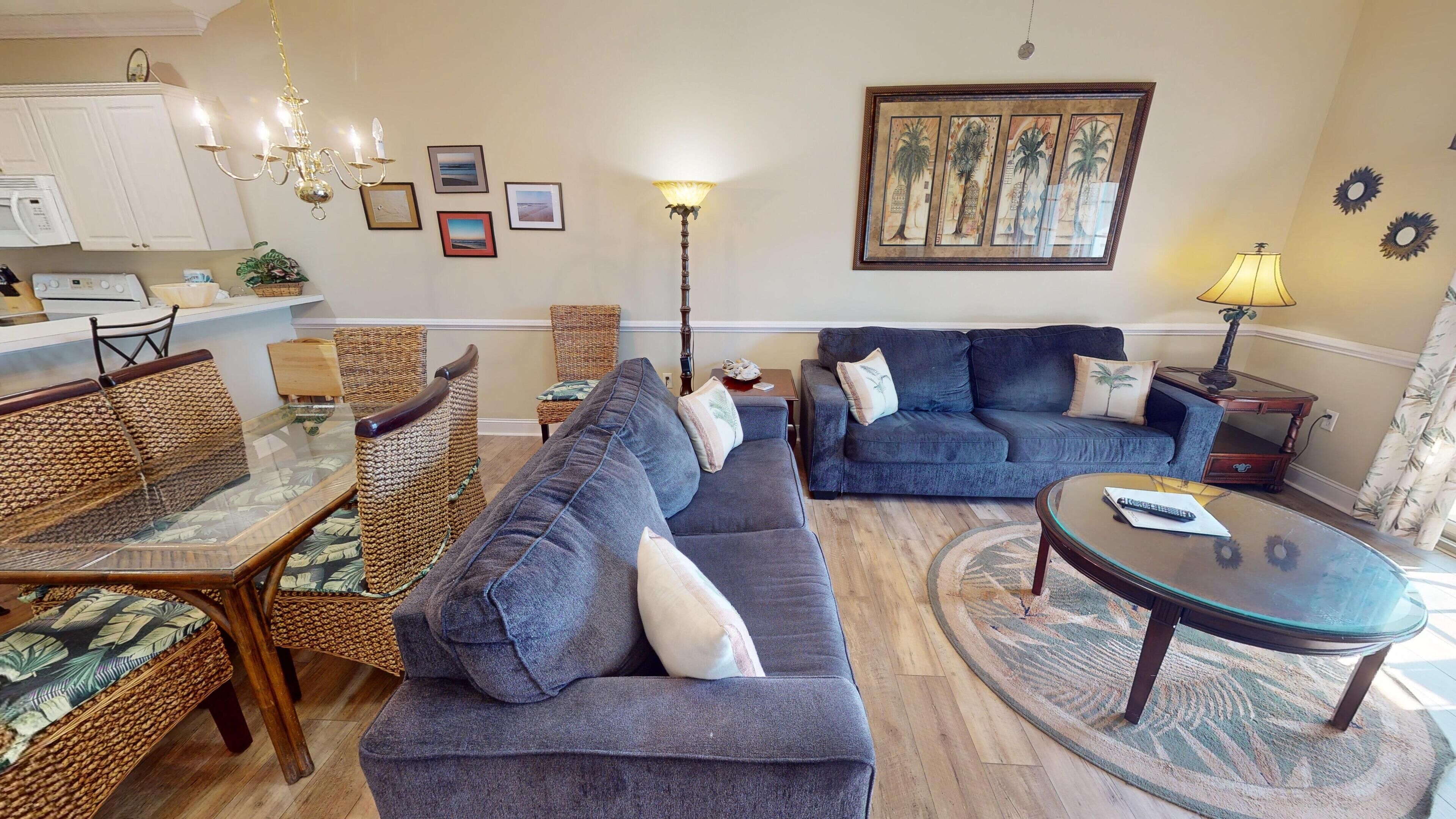 A living room with a sofa, chairs, a coffee table, and a dining table.