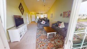 A living room with a TV, sofas, a coffee table, and a patterned rug.
