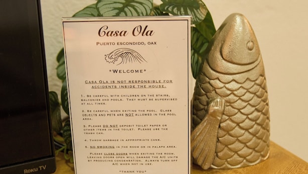 A sign for Casa Ola in Puerto Escondido, Oax. It includes safety instructions and a welcome message.