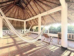 A thatched-roof gazebo with a hammock and a wooden chair. - Chic 3-bedroom villa with AC and WiFi in welcoming Puerto Escondido (Puerto Escondido)