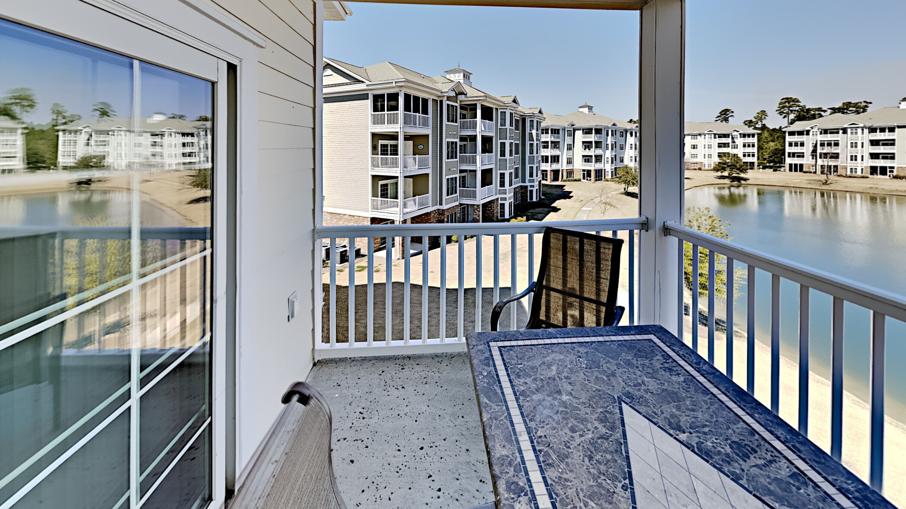 Un balcon donnant sur le front de mer et sur des immeubles à plusieurs étages.
