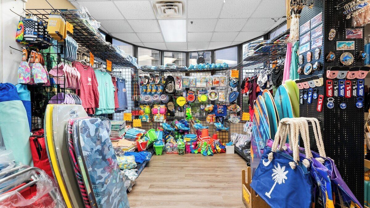 A store with various items on shelves and racks, including bags, hats, and accessories.
