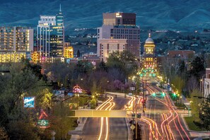 A cityscape with illuminated buildings, including a bank and a hotel, and a well-lit intersection with traffic lights. - Family-Friendly Stylish 5BR w/ Theater & Hot Tub in Meridian Idaho (Meridian)
