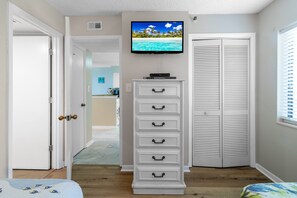 A bedroom with a bed, a dresser, a television on the wall, and a closet. - Oceanfront Dream | Peaceful Retreat by the Sea | SW 702 (North Myrtle Beach)
