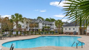 A swimming pool with lounge chairs and a lifeguard stand. - Arbor Trace 322, Condo by the Greens, Relaxing Golf Views Await (North Myrtle Beach)
