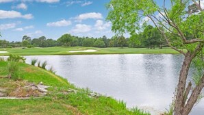 A serene lakeside view with a golf course in the background. - Arbor Trace 322, Condo by the Greens, Relaxing Golf Views Await (North Myrtle Beach)