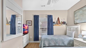 A bedroom with two beds, a TV, a dresser, and a window with curtains. - Arbor Trace 724, Tranquil Golf Views, Walk to Tee Time Daily (North Myrtle Beach)