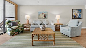 A living room with a sofa, two armchairs, a coffee table, and two lamps.