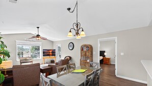 A spacious living room with a dining area, a fireplace, and a large window. - River Oaks Getaway | Golf, Beach, Fun – All in One! | Fairways 26E (Myrtle Beach)