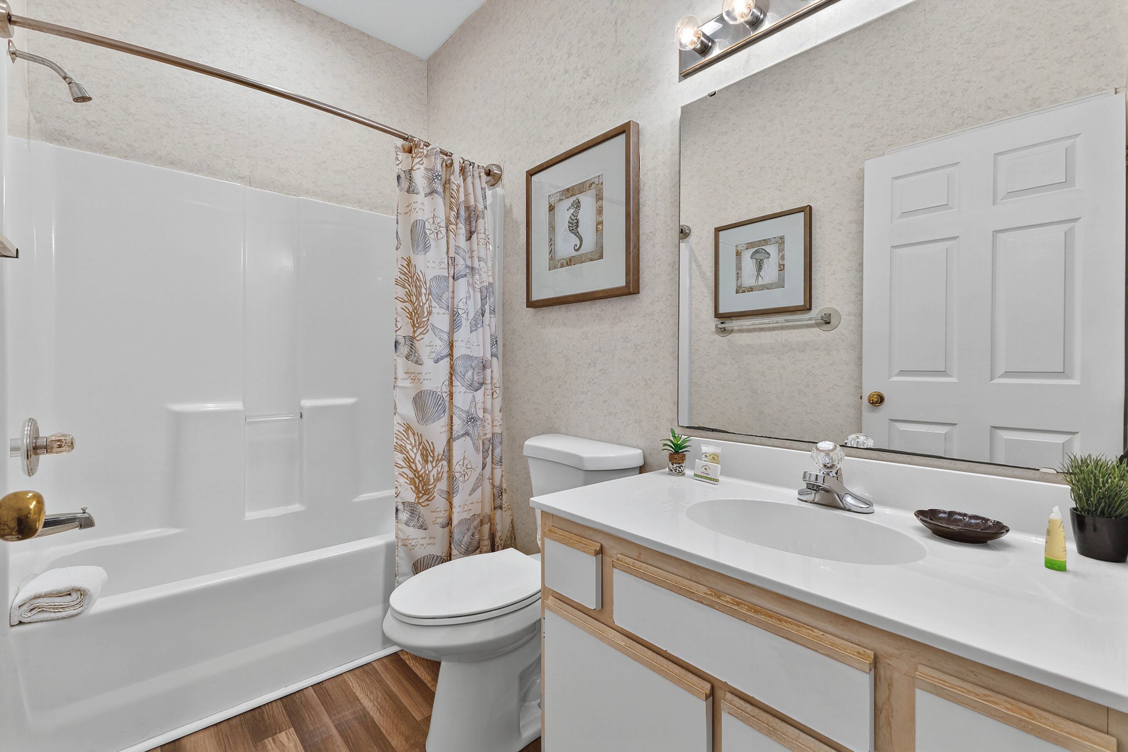 A bathroom with a bathtub, toilet, sink, and a shower curtain.