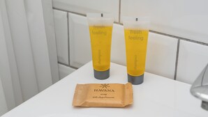 Deux bouteilles de shampoing « à la sensation de fraîcheur » et un paquet de savon « HAVANA aux éléments oxygénés » sur une surface blanche.