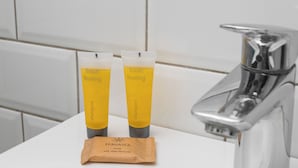 Twee gele tubes met de tekst 'fresh feeling' en een bruin zeepstuk op een witte wasbak.