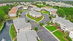 A residential area with apartment buildings, a parking lot, and a river. - North Myrtle Beach | Your Golf & Beach Getaway | IW721 (North Myrtle Beach)