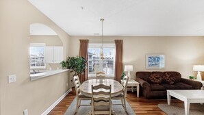 A living room with a dining table, sofa, and a view of the outside. - North Myrtle Beach | Your Golf & Beach Getaway | IW721 (North Myrtle Beach)