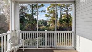 A covered porch with a white bench and a view of trees and hills. - North Myrtle Beach | Your Golf & Beach Getaway | IW721 (North Myrtle Beach)