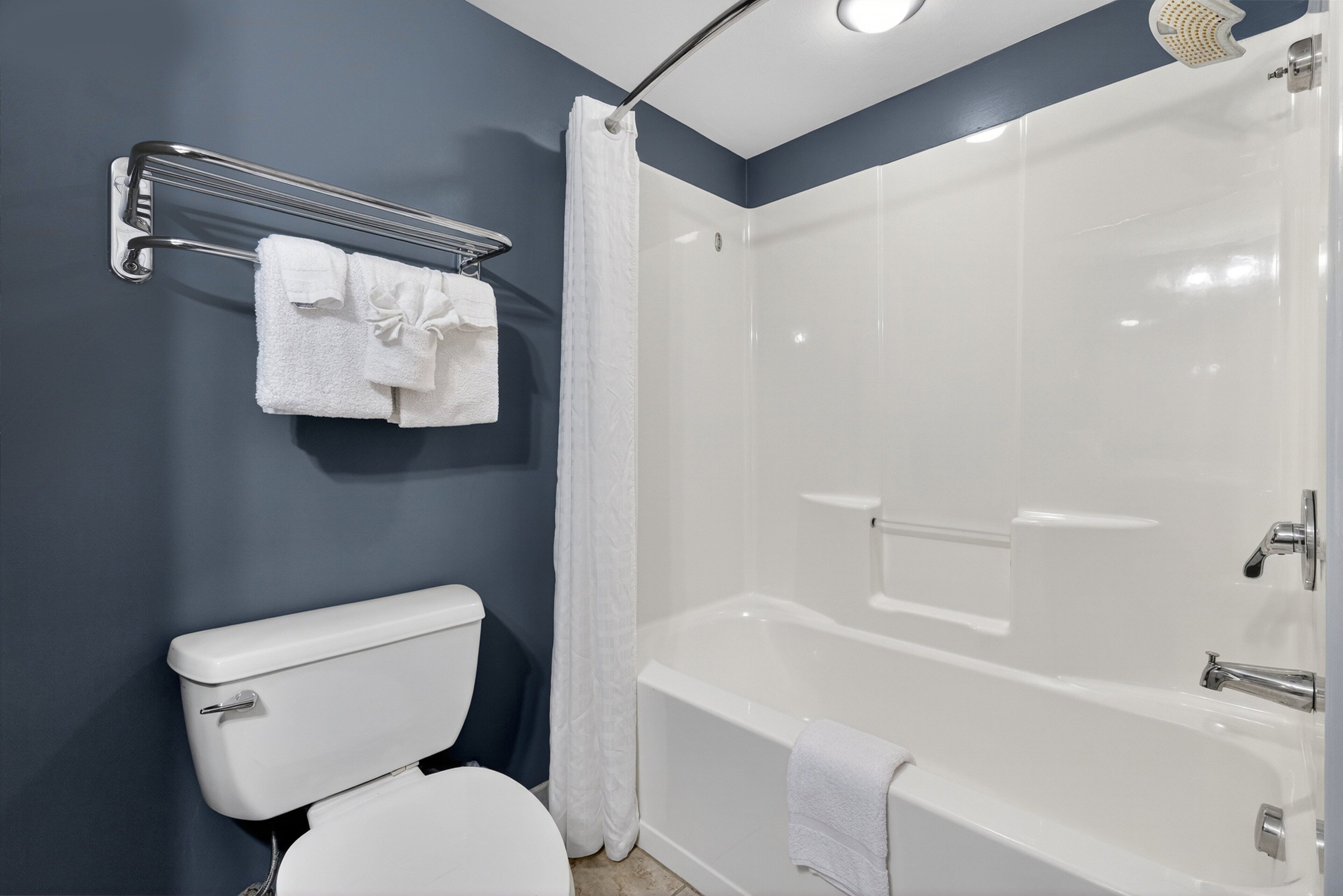 Un bagno moderno con un water bianco, una cabina doccia in vetro e una vasca da bagno.