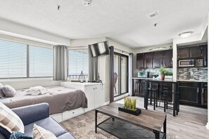 A compact living space with a bed, sofa, dining table, and kitchenette. - Ocean View Comfort | Steps from Ocean | Book Today | RT 1909 (Myrtle Beach)