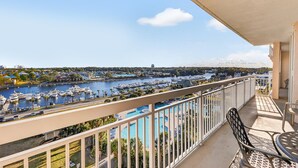 Ein Balkon mit Blick auf eine Marina, Boote und eine entfernte Kuppelstruktur.