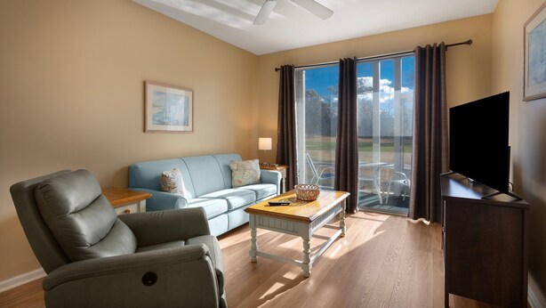 A living room with a sofa, armchair, coffee table, and a flat-screen TV. - Escape to River Oaks | Golf, Beach & More Await! | RO 50B (Myrtle Beach)