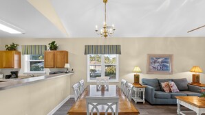 A spacious living area with a dining table, sofas, and a kitchen area. - Willowbend 831 - Barefoot (North Myrtle Beach)