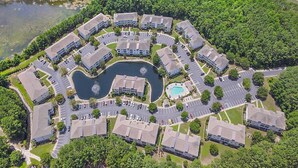 An aerial view of a residential complex with multiple buildings, a central circular driveway, and a swimming pool. - Willowbend 831 - Barefoot (North Myrtle Beach)