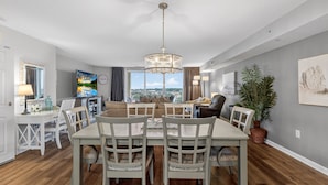 A dining area with a chandelier, a large window, and a view of the city. - Yacht Club 2-802 - North Myrtle Beach (North Myrtle Beach)