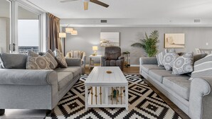A modern living room with two grey sofas, a white coffee table, and a ceiling fan. - Yacht Club 2-802 - North Myrtle Beach (North Myrtle Beach)
