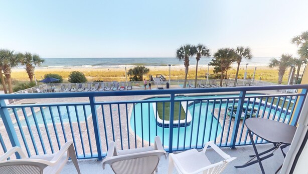 A pool area with lounge chairs and a view of the beach. - Atlantica 154, Beachfront Myrtle Beach Sping Retreat (Myrtle Beach)