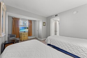 A hotel room with two beds, a television, a desk, and a wardrobe.