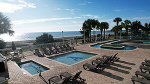A pool area with multiple pools, lounge chairs, and a view of the ocean. - Atlantica 754, Beachfront Charm, Oceanfront Views, Beach Escape (Myrtle Beach)