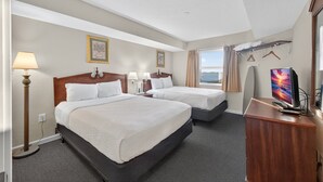 A hotel room with two beds, a desk with a TV, a lamp, and a window with curtains. - Atlantica 854, Oceanfront | Myrtle Beach Serenity Condo (Myrtle Beach)